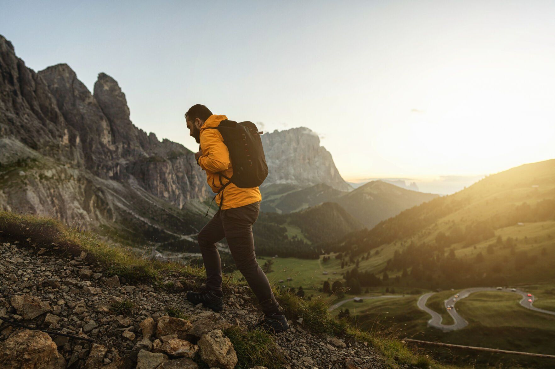 Man mountain hiking at sunset on the Dolomites: outdoor adventure